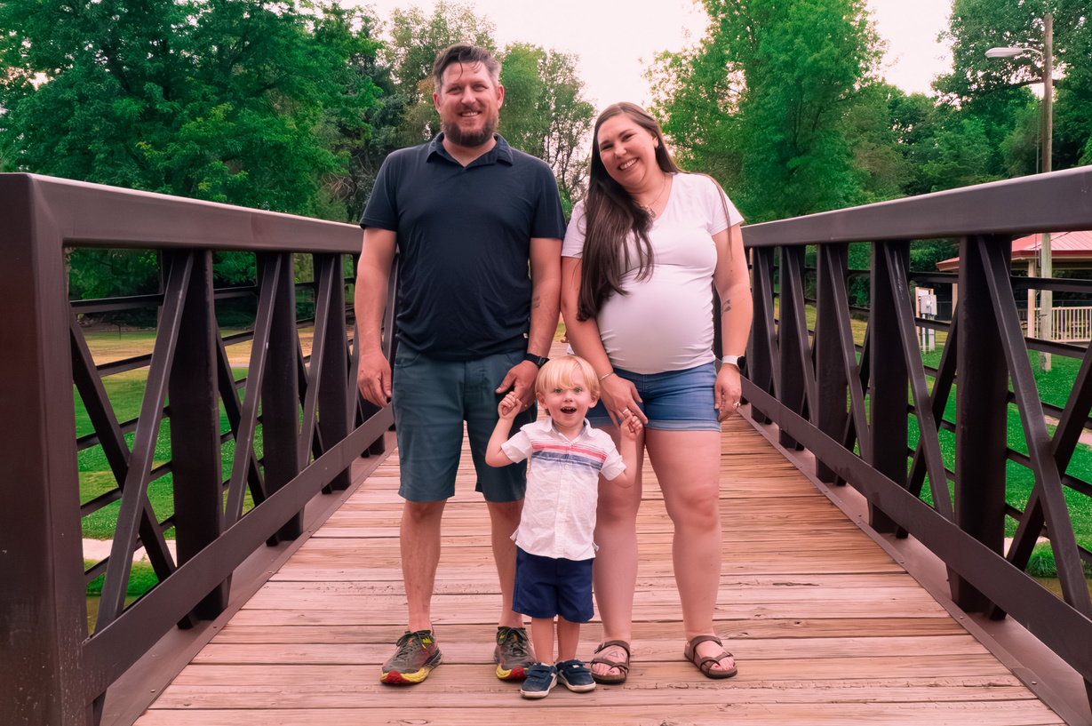 a person, person and child standing on a wooden bridge