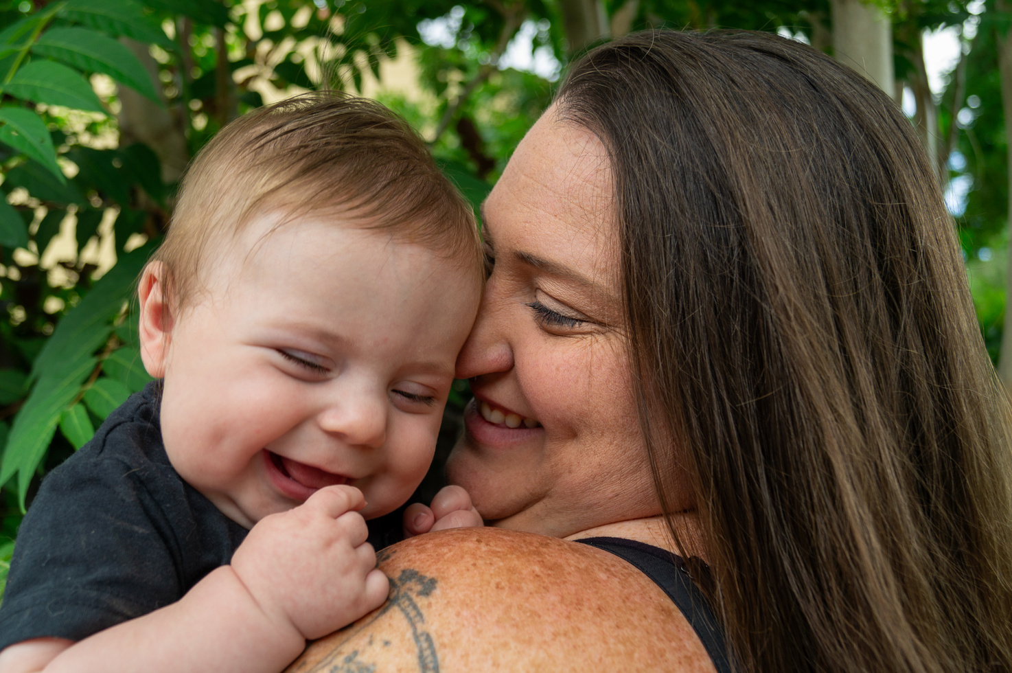 a person is holding a baby and smiling