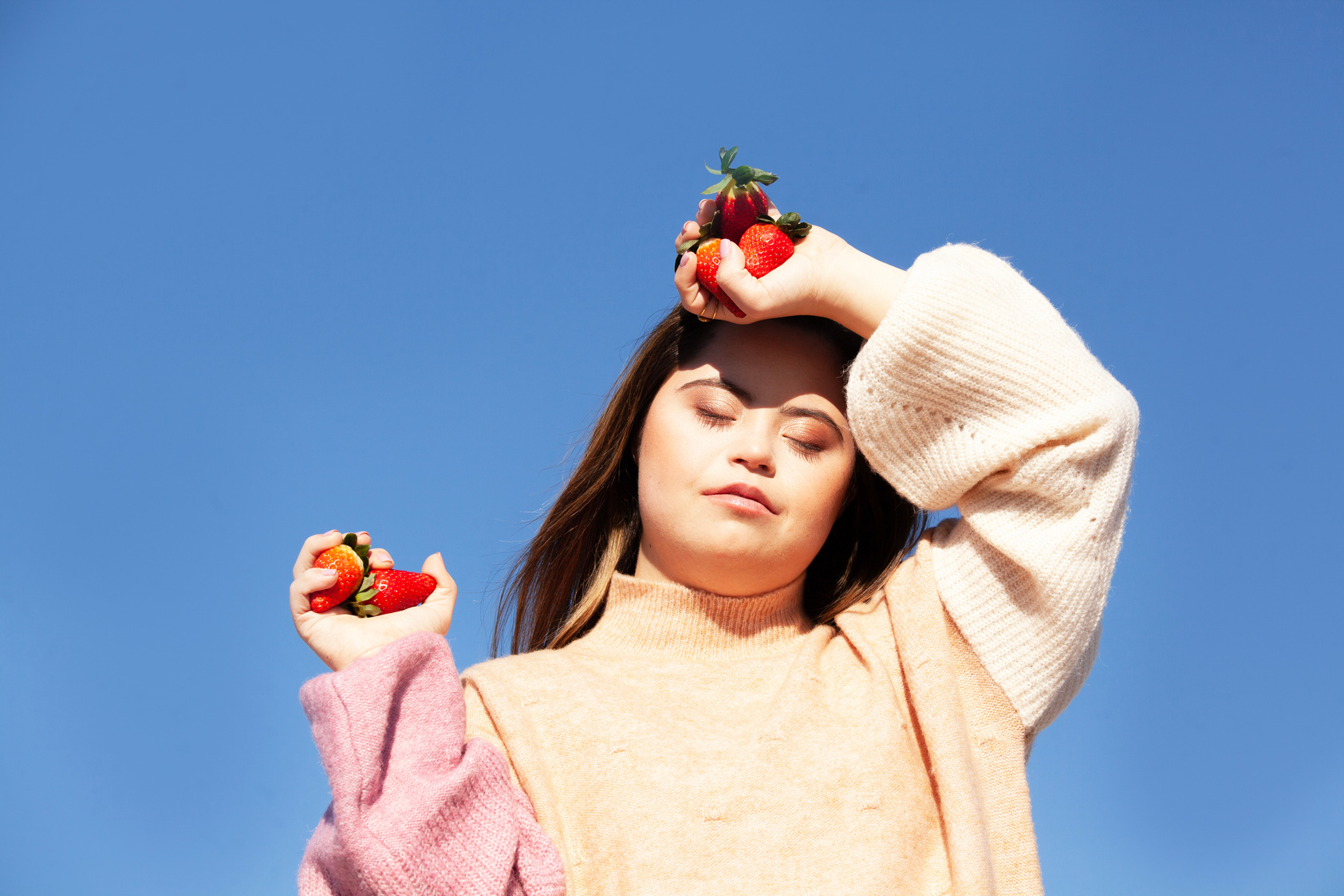 a person is holding two strawberries in their hands