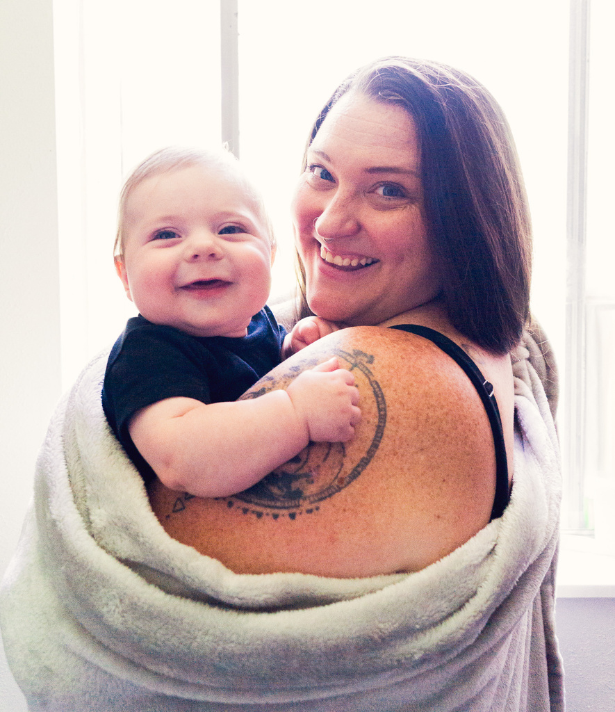 a person is holding a baby and smiling