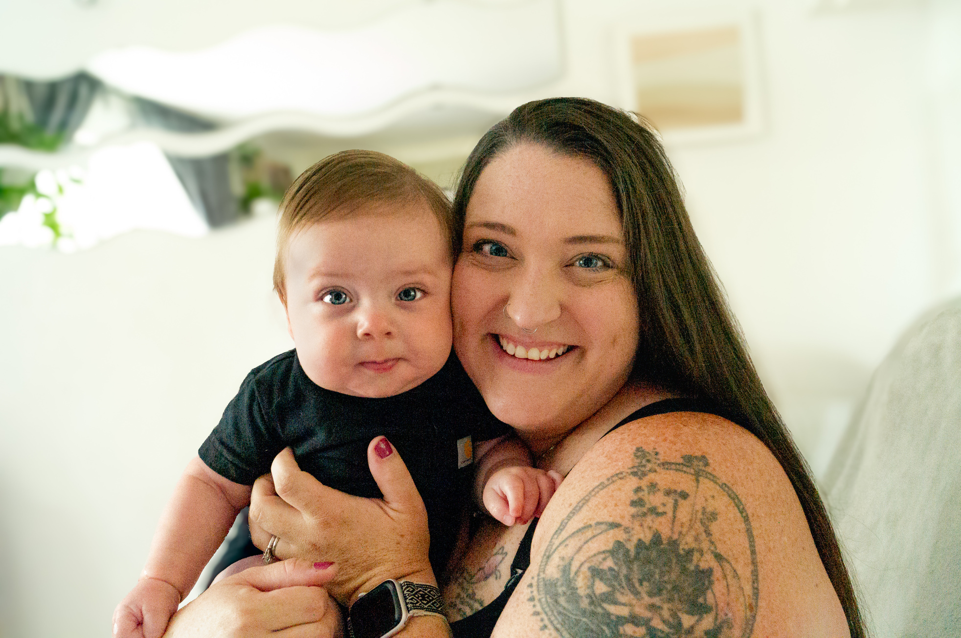 a person with tattoos holding a baby