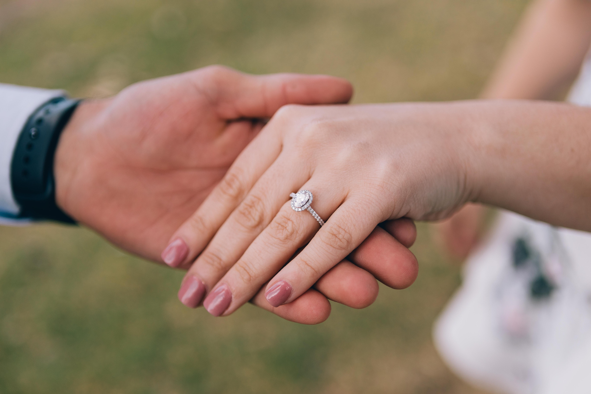 a person holding another person's hand with a diamond engagement ring