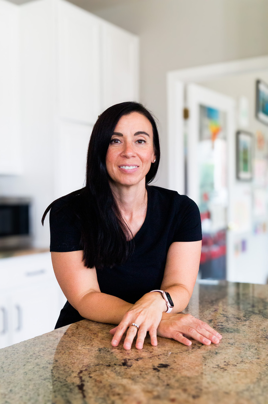 a person in a black shirt sitting at the kitchen counter