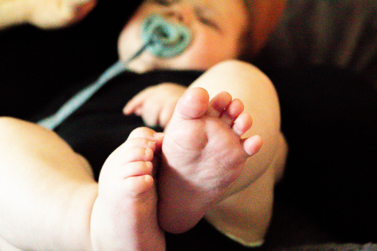 a close up of a baby with a pacifier in their mouth