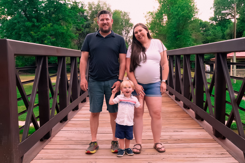 Three people standing on a bridge