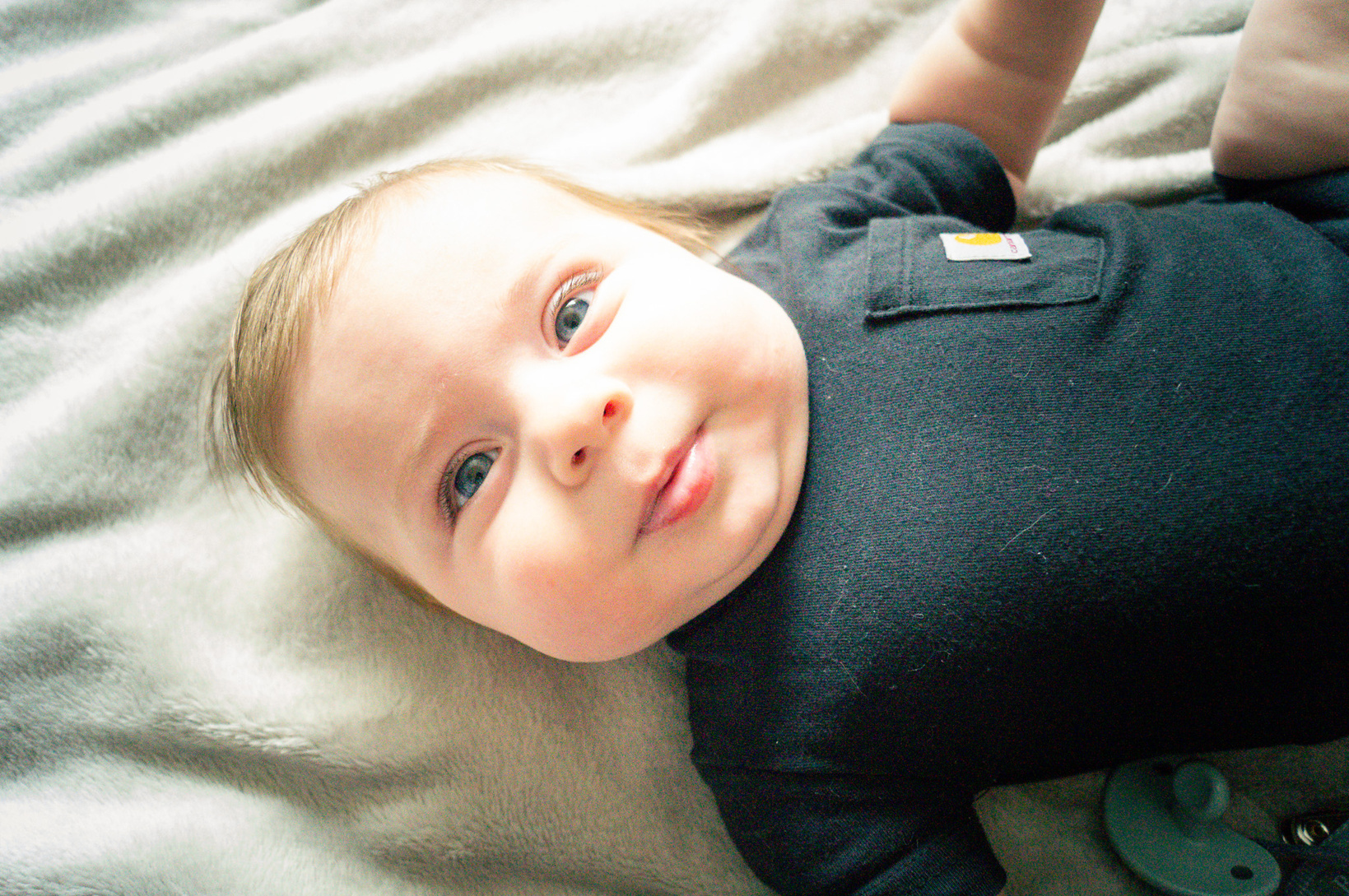 a close up of a baby laying on a blanket