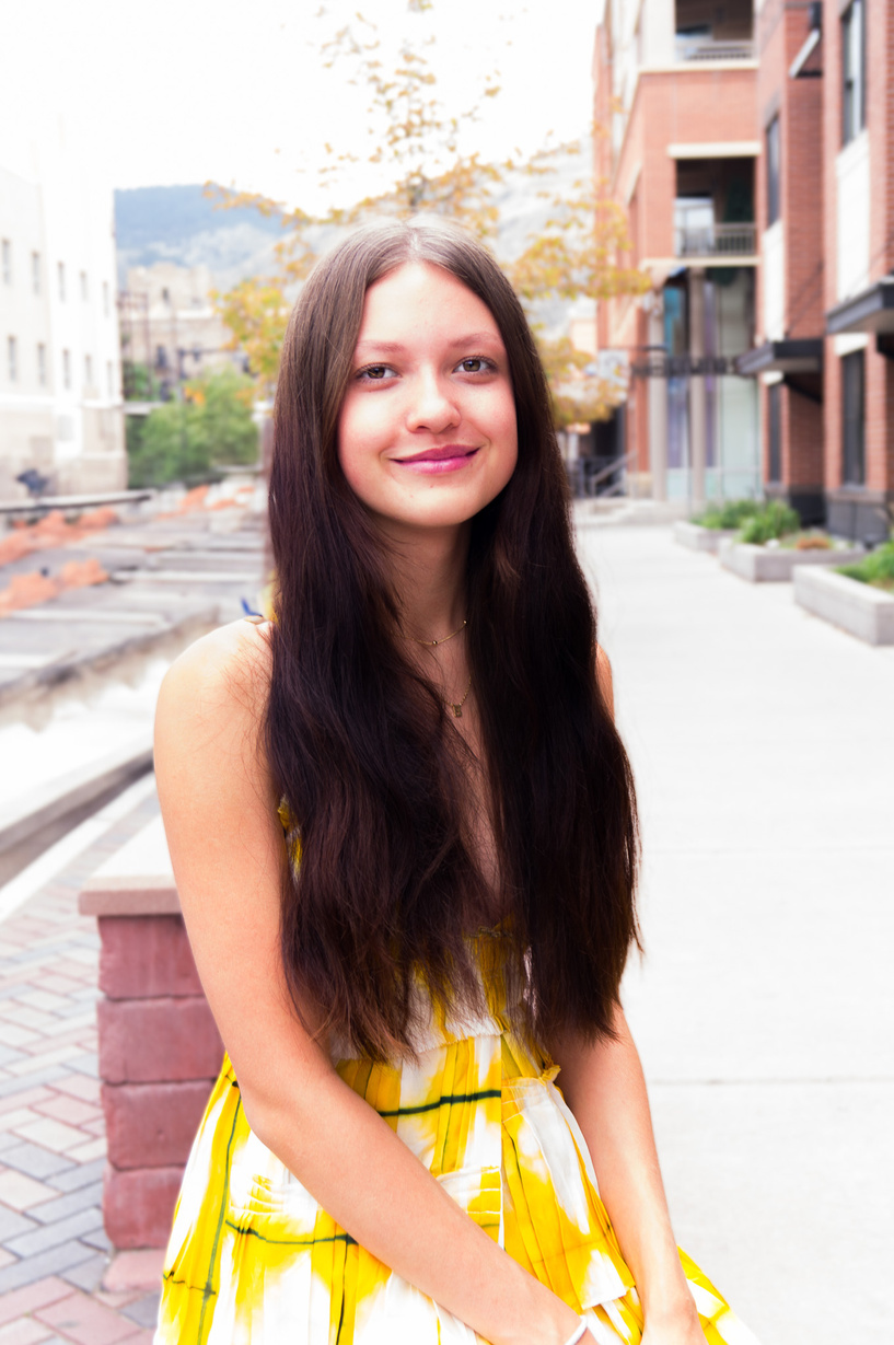 a person with long hair wearing a yellow dress