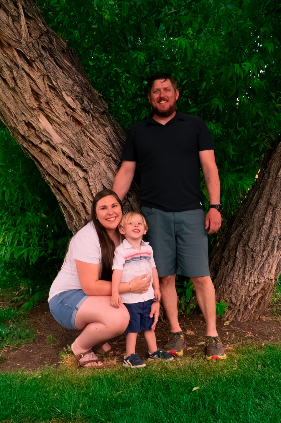 a person, person and child pose for a photo in front of a tree