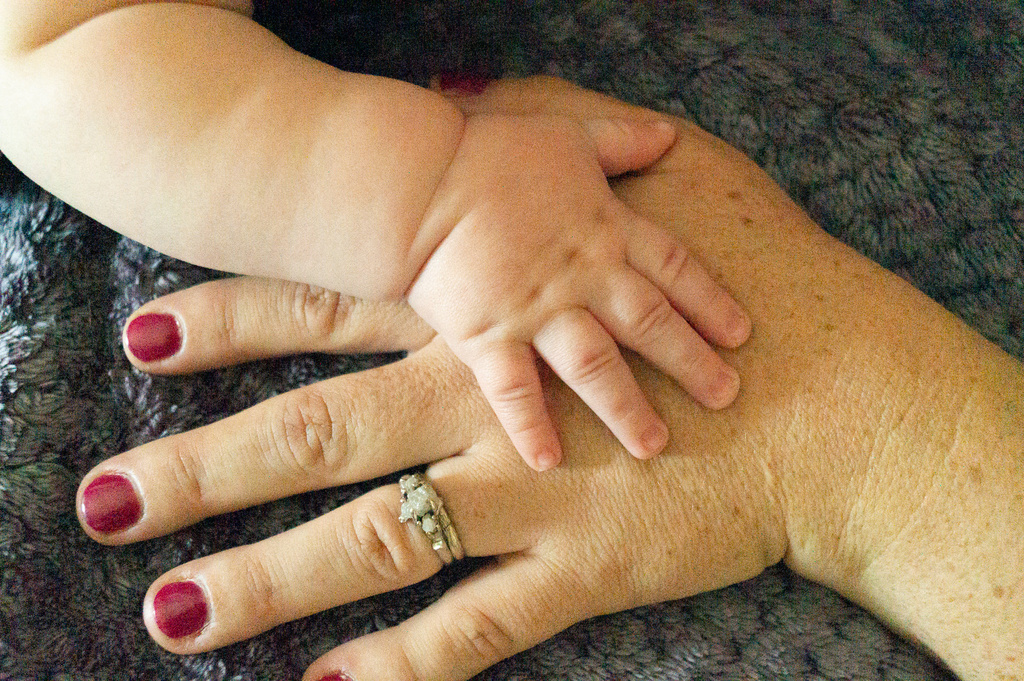 a close up of a hand holding a baby's hand